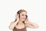 Young woman listening music through headphones