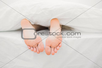 Womans feet sticking out of blanket