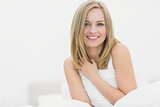 Portrait of smiling woman sitting in bed