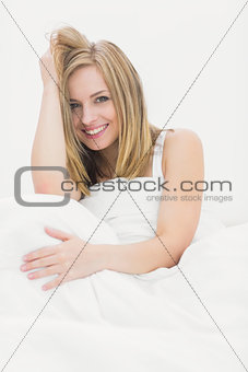 Portrait of beautiful woman sitting in bed