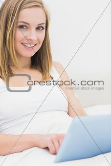 Portrait of woman using digital tablet in bed
