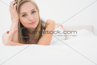 Portrait of beautiful woman lying in bed
