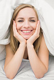 Closeup portrait of beautiful woman under sheet in bed