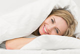 Portrait of happy beautiful woman in bed