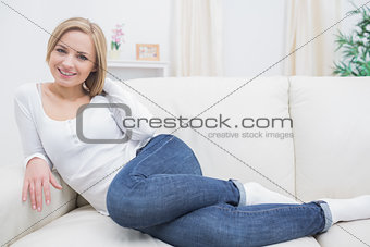 Portrait of casual happy woman sitting on sofa