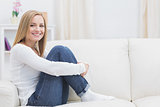 Portrait of casual happy woman sitting on sofa