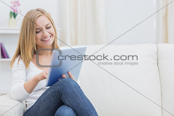 Casual happy woman using digital tablet on sofa