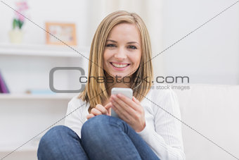 Woman with mobile phone sitting on couch