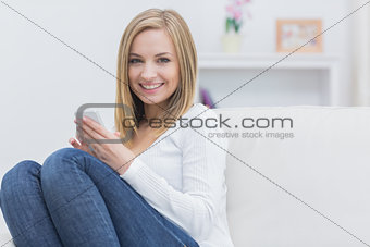 Portrait of woman with mobile phone at home