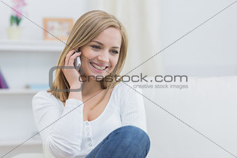 Casual young woman using mobile phone at home
