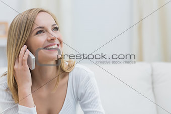 Casual young woman using mobile phone at home