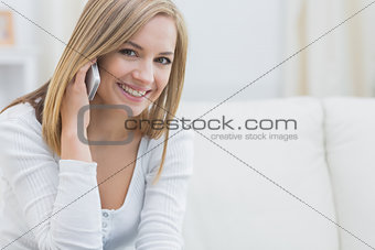Portrait of casual young woman using mobile phone at home