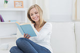 Happy woman reading storybook at home