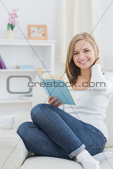 Portrait of happy woman with storybook at home