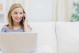 Casual woman using laptop and cellphone at home