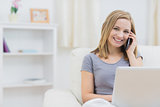 Portrait of woman using laptop and cellphone at home