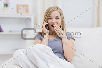 Portrait of surprised woman using cellphone at home