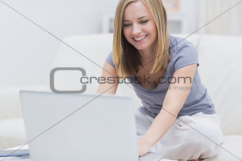 Casual happy woman using laptop at home