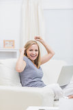 Portrait of excited casual woman with laptop at home