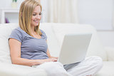 Happy casual woman using laptop at home