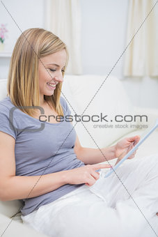 Casual happy woman using digital tablet in living room