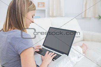Casual woman using laptop in living room