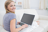 Portrait of casual woman using laptop in living room