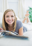 Casual woman with magazine lying on couch