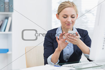 Business woman text messaging at office desk