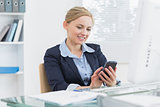 Young business woman text messaging office desk