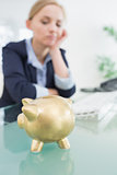 Upset business woman with piggy bank at office