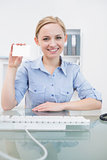 Portrait of female executive holding blank card at office