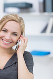 Smiling business woman using mobile phone in office
