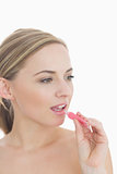 Closeup of young woman applying lipgloss