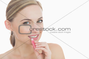 Closeup portrait of young woman applying lipgloss
