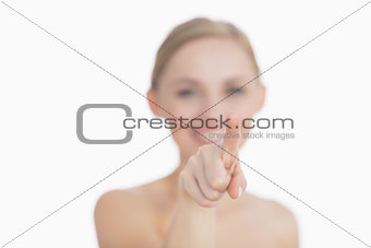 Beautiful young woman pointing at invisible screen