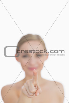 Young woman pointing at invisible screen