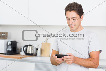 Man texting in the kitchen