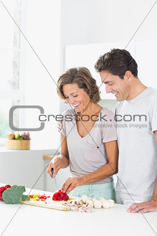 Smiling couple preparing vegetables