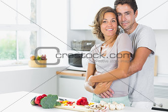 Wife and husband embracing in the kitchen