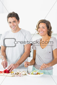 Happy couple preparing salad