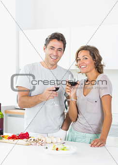 Couple drinking red wine and preparing salad