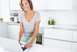 Pretty woman in kitchen with laptop
