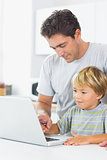 Happy father and son using laptop