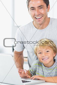Happy son and father with laptop