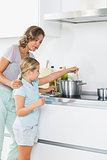 Mother teaching daughter how to cook