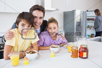 Happy father and children at breakfast