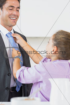 Daughter adjusting fathers tie