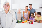 Happy grandfather standing by kitchen counter