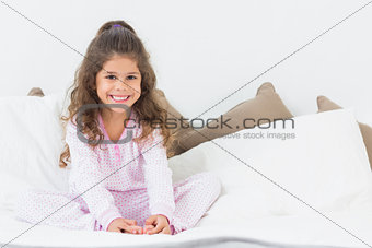 Cute girl sitting on bed